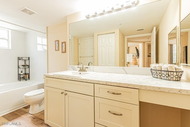 8617 River Homes Ln Unit 3108, Bonita Springs, FL 34135 - bathroom featuring toilet, vanity, a tub to relax in, and wood finished floors