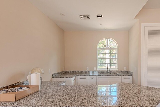 8617 River Homes Ln Unit 3108, Bonita Springs, FL 34135 - kitchen featuring a sink, white cabinetry, light stone counters, and recessed lighting
