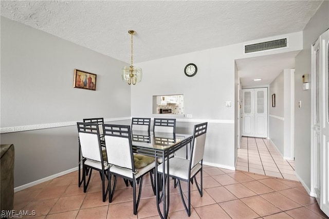 1624 Pine Valley Dr Unit 115, Fort Myers, FL 33907 - dining room featuring a textured ceiling, a chandelier, light tile patterned floors, baseboards, and visible vents