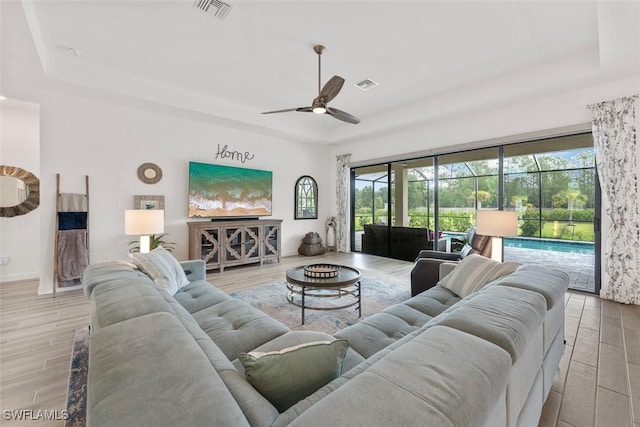 14071 Binghampton Dr, Fort Myers, FL 33905 - living area with a tray ceiling, ceiling fan, wood finished floors, and healthy amount of natural light