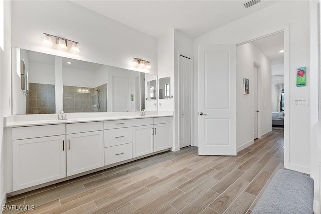 14071 Binghampton Dr, Fort Myers, FL 33905 - ensuite bathroom with double vanity, a walk in shower, and wood finished floors