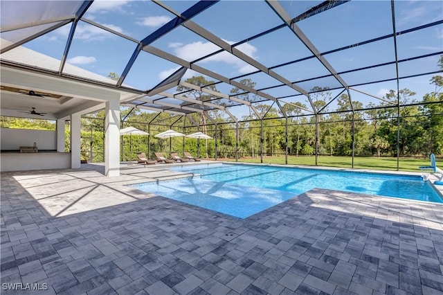pool featuring ceiling fan, glass enclosure, and a patio