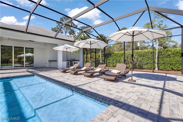 outdoor pool with a patio area, a ceiling fan, and glass enclosure