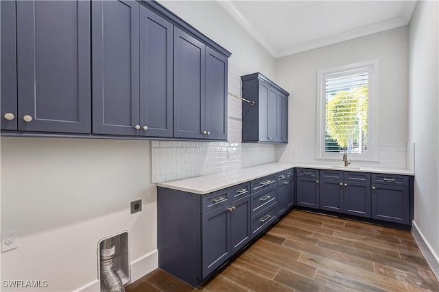 clothes washing area featuring a sink, hookup for an electric dryer, cabinet space, crown molding, and dark wood-type flooring