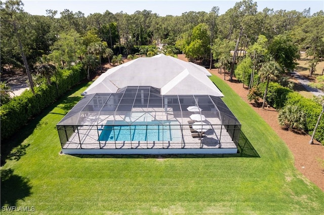 pool with glass enclosure, a yard, and a patio
