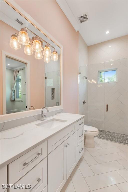 full bath featuring toilet, vanity, visible vents, and a stall shower