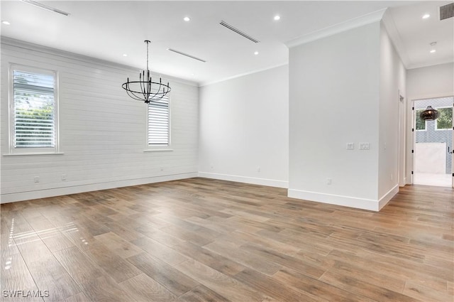 unfurnished dining area featuring light wood-style floors, ornamental molding, baseboards, and a notable chandelier