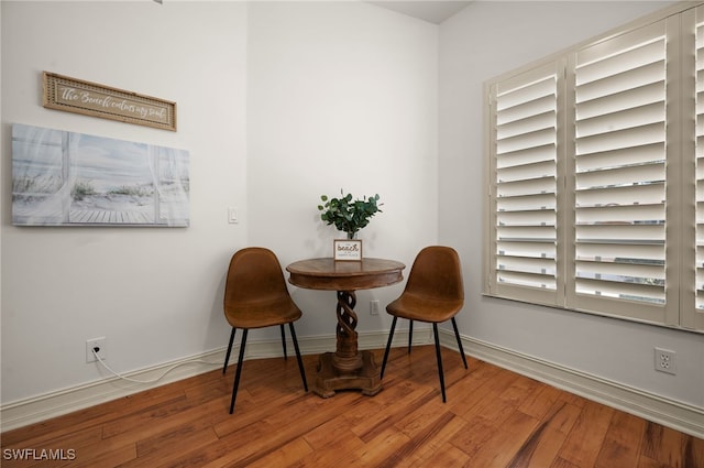 dining area with baseboards and wood finished floors