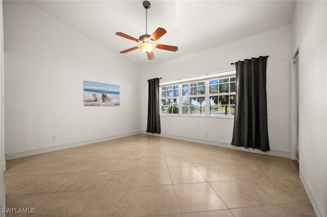 spare room with ceiling fan, lofted ceiling, light tile patterned floors, and baseboards