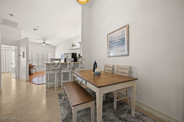 dining room with baseboards, a ceiling fan, visible vents, and light tile patterned floors