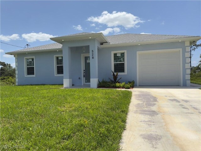 528 Aspen Ave S, Lehigh Acres, FL 33974 - view of front of property with stucco siding, driveway, a front yard, and an attached garage