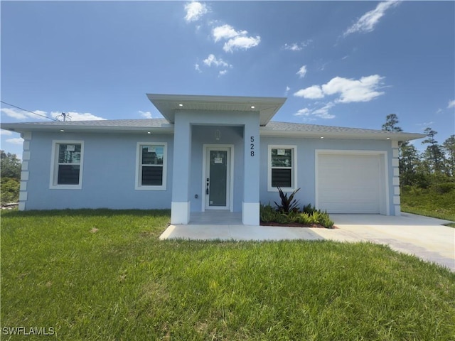 528 Aspen Ave S, Lehigh Acres, FL 33974 - view of front facade with stucco siding, driveway, a garage, and a front lawn