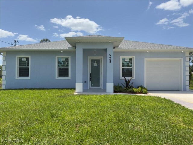 528 Aspen Ave S, Lehigh Acres, FL 33974 - view of front of house with stucco siding, a garage, a front lawn, driveway, and a shingled roof