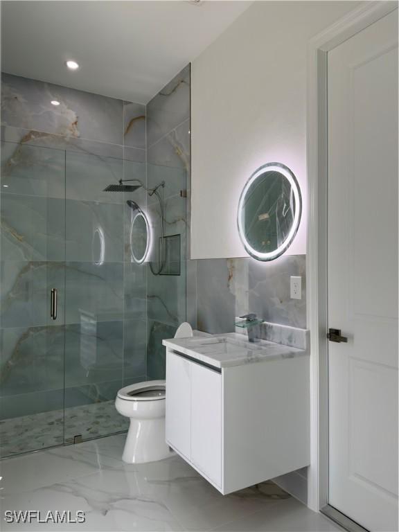 528 Aspen Ave S, Lehigh Acres, FL 33974 - full bath featuring a marble finish shower, vanity, tile walls, toilet, and marble finish flooring