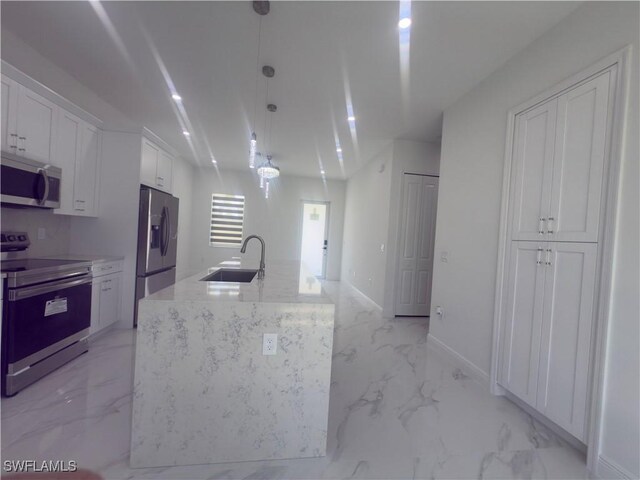 528 Aspen Ave S, Lehigh Acres, FL 33974 - kitchen featuring appliances with stainless steel finishes, a sink, light marble finish flooring, white cabinets, and decorative light fixtures
