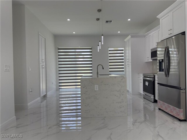 528 Aspen Ave S, Lehigh Acres, FL 33974 - kitchen featuring stainless steel appliances, light marble finish floors, white cabinets, a sink, and a kitchen island with sink