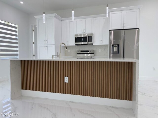 528 Aspen Ave S, Lehigh Acres, FL 33974 - kitchen with stainless steel appliances, light marble finish flooring, decorative backsplash, light countertops, and white cabinetry