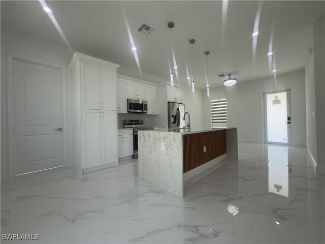 528 Aspen Ave S, Lehigh Acres, FL 33974 - kitchen featuring appliances with stainless steel finishes, white cabinets, and light marble finish floors