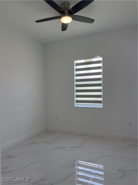 528 Aspen Ave S, Lehigh Acres, FL 33974 - unfurnished room featuring baseboards, marble finish floors, and a ceiling fan