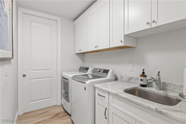 2008 SW 44th Ter, Cape Coral, FL 33914 - washroom featuring separate washer and dryer, cabinet space, and light wood-style floors