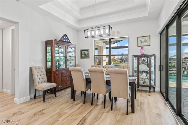 2008 SW 44th Ter, Cape Coral, FL 33914 - dining space featuring a raised ceiling, light wood-style flooring, a chandelier, baseboards, and crown molding