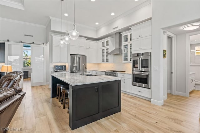 2008 SW 44th Ter, Cape Coral, FL 33914 - kitchen featuring wall chimney exhaust hood, appliances with stainless steel finishes, a sink, open floor plan, and light wood-type flooring