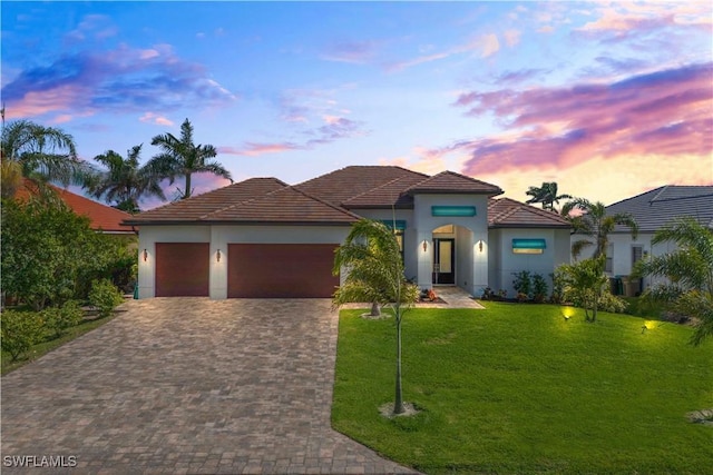 2008 SW 44th Ter, Cape Coral, FL 33914 - mediterranean / spanish-style house featuring decorative driveway, an attached garage, a front lawn, and stucco siding