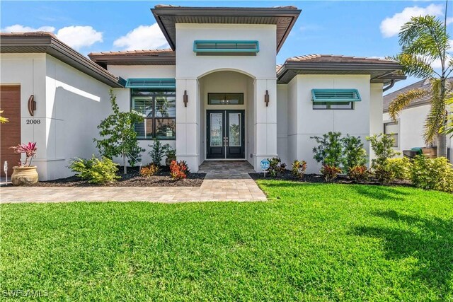 2008 SW 44th Ter, Cape Coral, FL 33914 - doorway to property with french doors, a lawn, stucco siding, and a tile roof