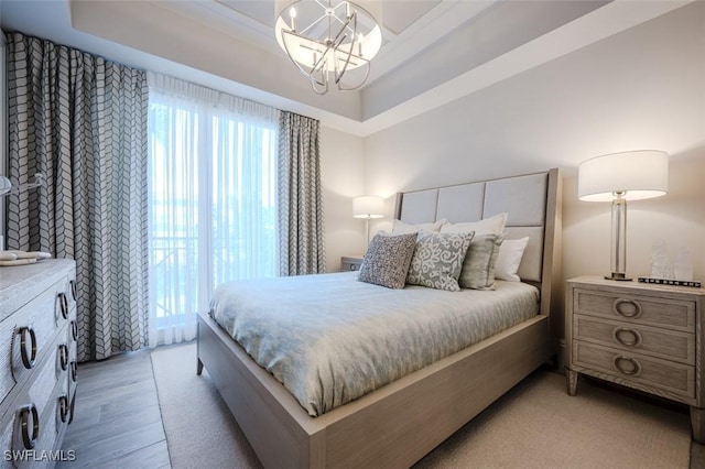 bedroom featuring an inviting chandelier and light wood finished floors