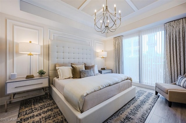 bedroom featuring beam ceiling, wood finished floors, a chandelier, and coffered ceiling