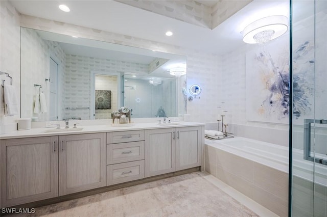 bathroom with a stall shower, double vanity, a bath, and a sink