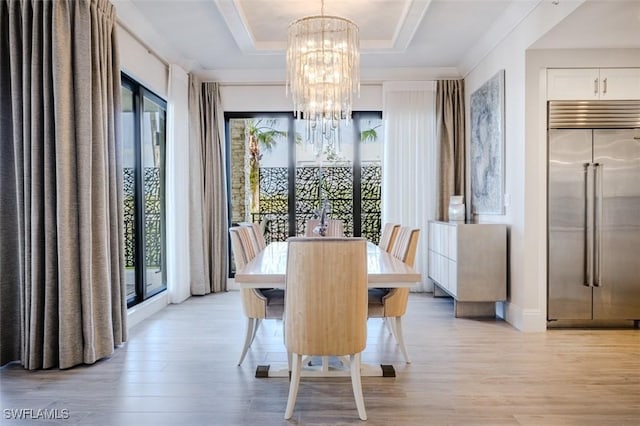 dining space with light wood-style floors, plenty of natural light, and a notable chandelier