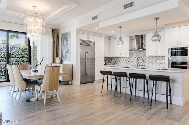 dining area featuring visible vents, plenty of natural light, and light wood-style flooring