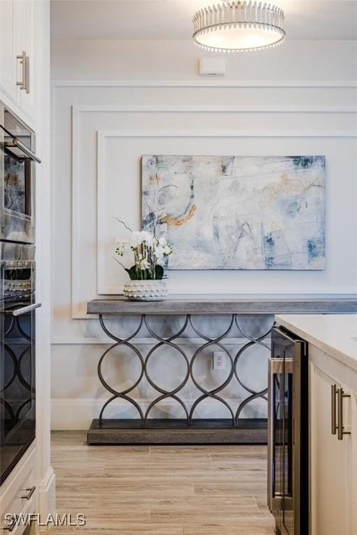 details with wine cooler, wood finished floors, and baseboards