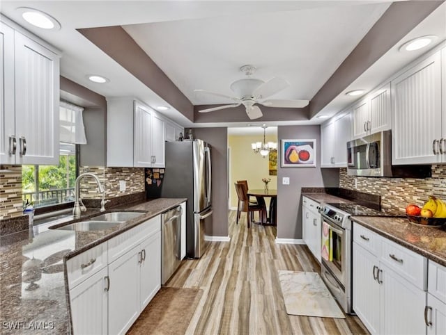 6030 Birnam Wood Ln, Fort Myers, FL 33908 - kitchen featuring ceiling fan with notable chandelier, stainless steel appliances, a sink, and white cabinetry