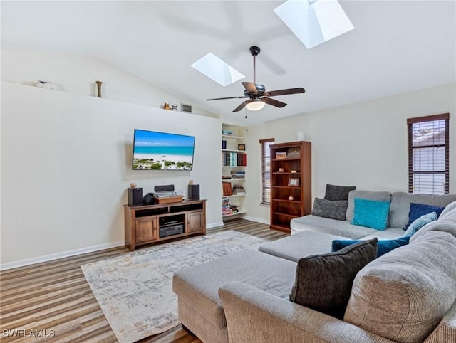 6030 Birnam Wood Ln, Fort Myers, FL 33908 - living room featuring ceiling fan, lofted ceiling with skylight, wood finished floors, and baseboards