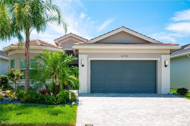 16733 Gilroy St, Bonita Springs, FL 34135 - ranch-style house with stucco siding, decorative driveway, an attached garage, and a tile roof