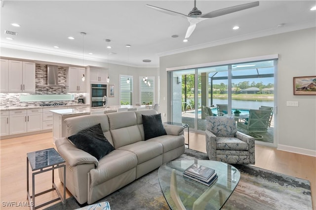 16733 Gilroy St, Bonita Springs, FL 34135 - living room featuring light wood-style floors, ceiling fan, recessed lighting, crown molding, and a water view