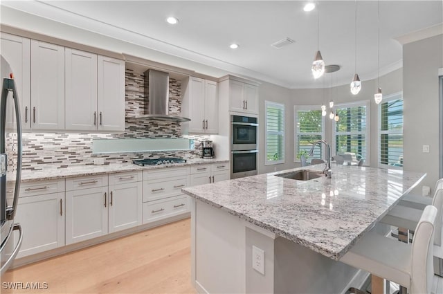 16733 Gilroy St, Bonita Springs, FL 34135 - kitchen with wall chimney range hood, appliances with stainless steel finishes, a sink, tasteful backsplash, and a kitchen breakfast bar