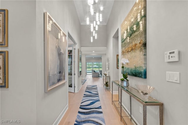 16733 Gilroy St, Bonita Springs, FL 34135 - hall with a chandelier, wood finished floors, baseboards, and a towering ceiling