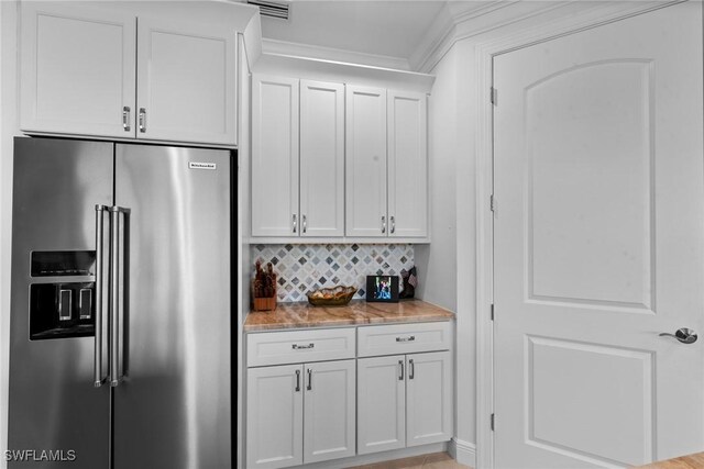 18580 Sandalwood Pointe Unit 101, Fort Myers, FL 33908 - kitchen with high quality fridge, white cabinetry, visible vents, light stone countertops, and backsplash