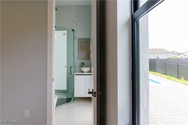 interior space with a sink, marble finish floor, and a healthy amount of sunlight