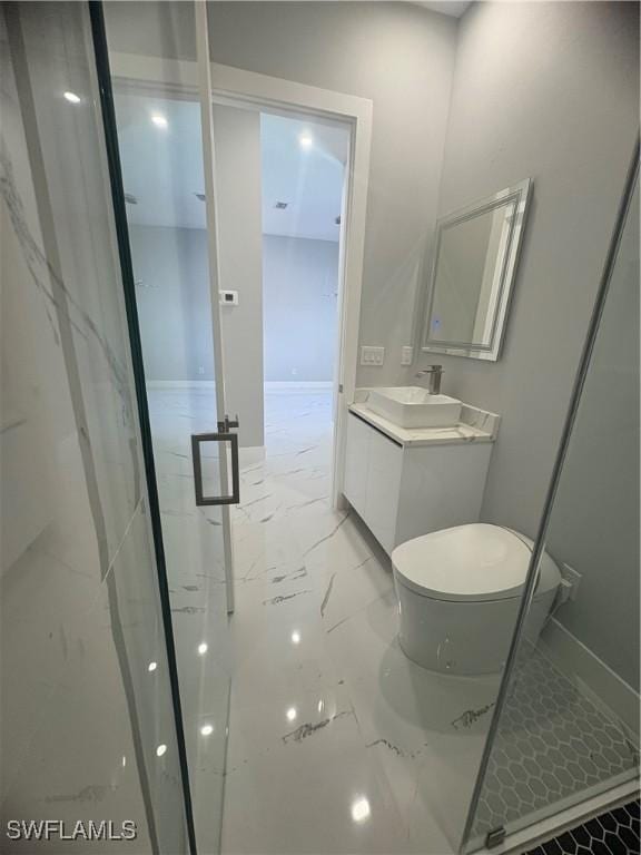 full bathroom featuring vanity, marble finish floor, toilet, baseboards, and a stall shower