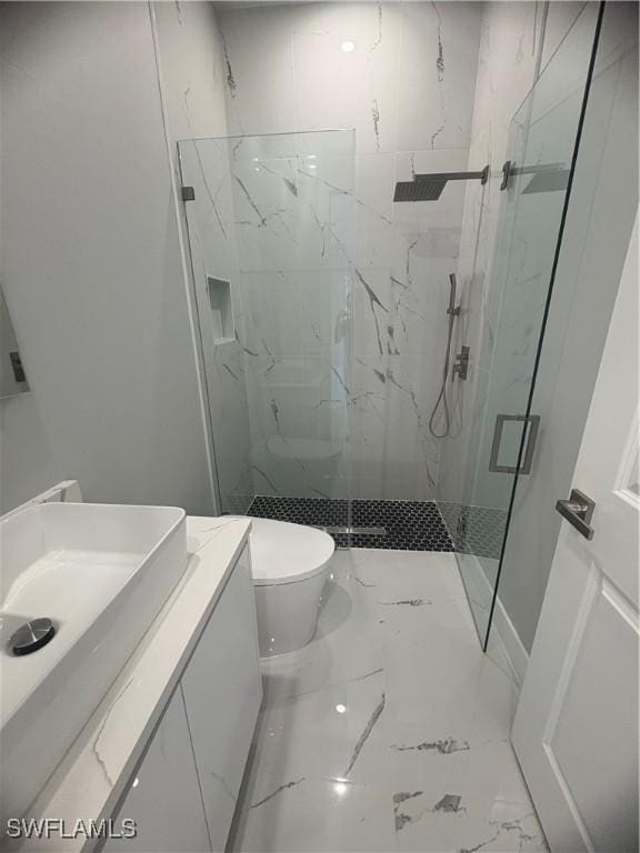 full bathroom featuring toilet, a marble finish shower, marble finish floor, and vanity