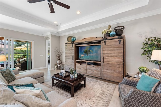 living area featuring a ceiling fan, crown molding, baseboards, a tray ceiling, and recessed lighting