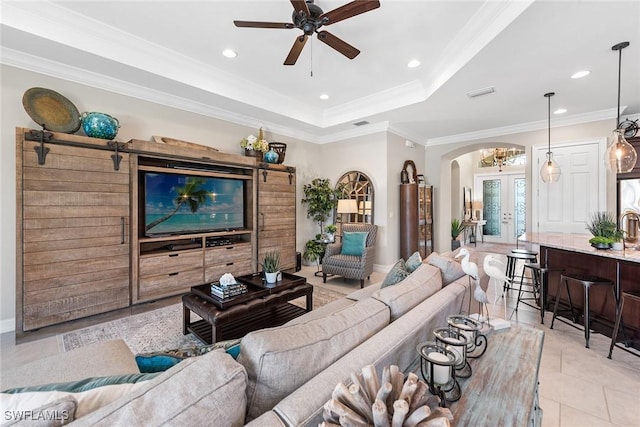 living room with arched walkways, a ceiling fan, recessed lighting, visible vents, and ornamental molding