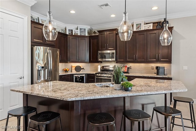 kitchen with a kitchen breakfast bar, dark brown cabinetry, stainless steel appliances, and visible vents