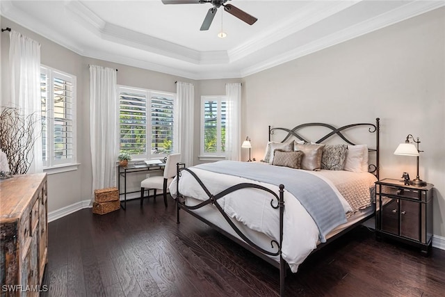 bedroom with crown molding, hardwood / wood-style floors, a tray ceiling, and multiple windows