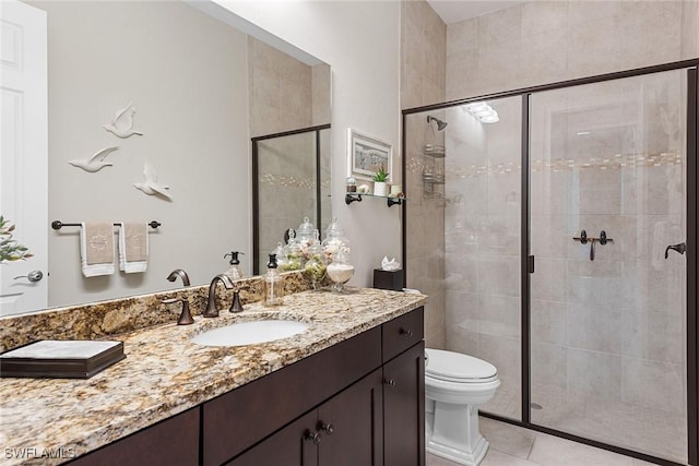full bath featuring vanity, tile patterned floors, a stall shower, and toilet