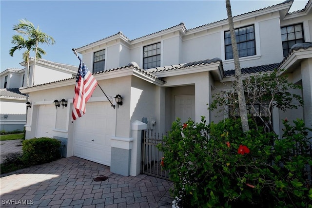 view of front of house with a tiled roof, stucco siding, and decorative driveway